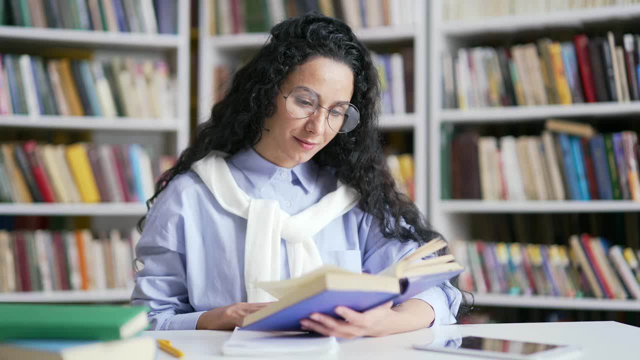 微笑的女学生在校园图书馆空间学习看书视频素材