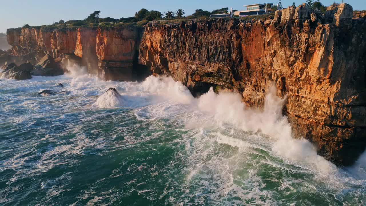 高空溅起的浪花撞击着海岸岩石鸟瞰图。强大的海浪。视频素材