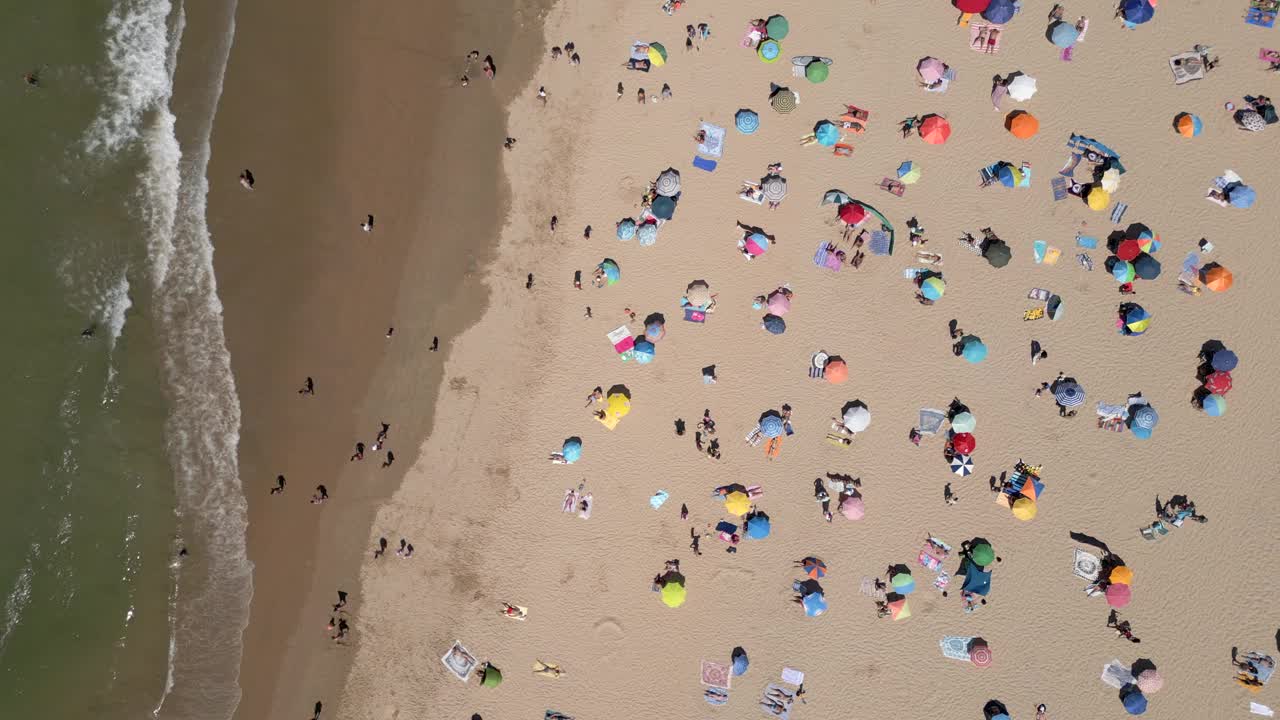 人们在葡萄牙里斯本附近的卡帕里卡海岸海滩上享受夏日美景的鸟瞰图视频素材