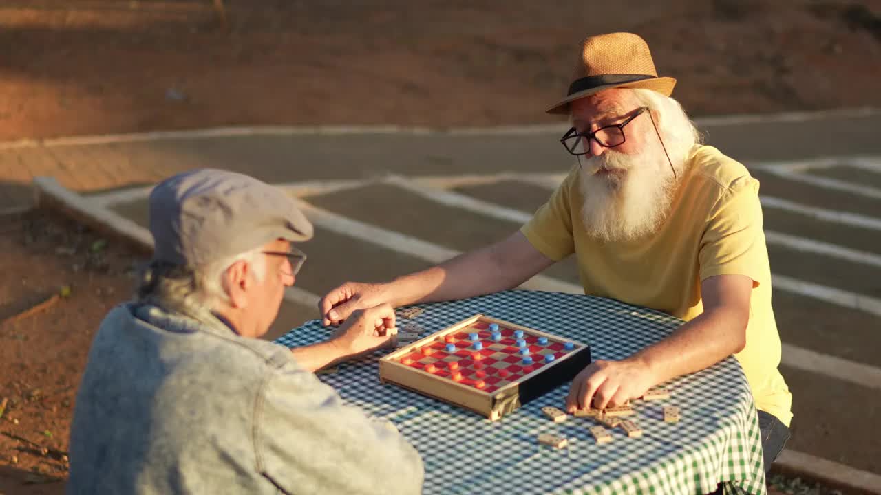 老人和他的朋友在公园里玩跳棋视频素材