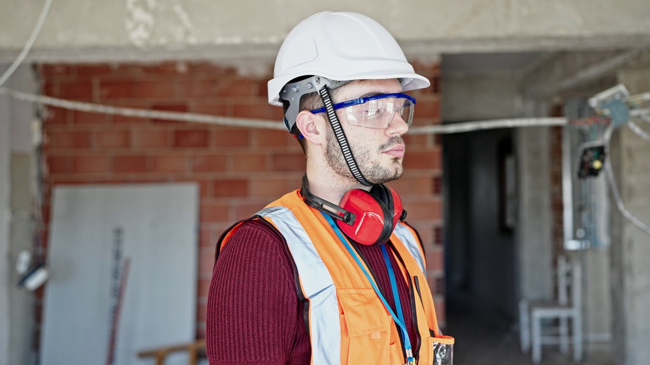 年轻的西班牙裔建筑工人一脸严肃地站在工地上视频素材