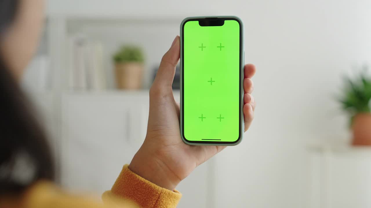 空白的亚洲女性手中的数码智能手机，手机绿屏视频素材