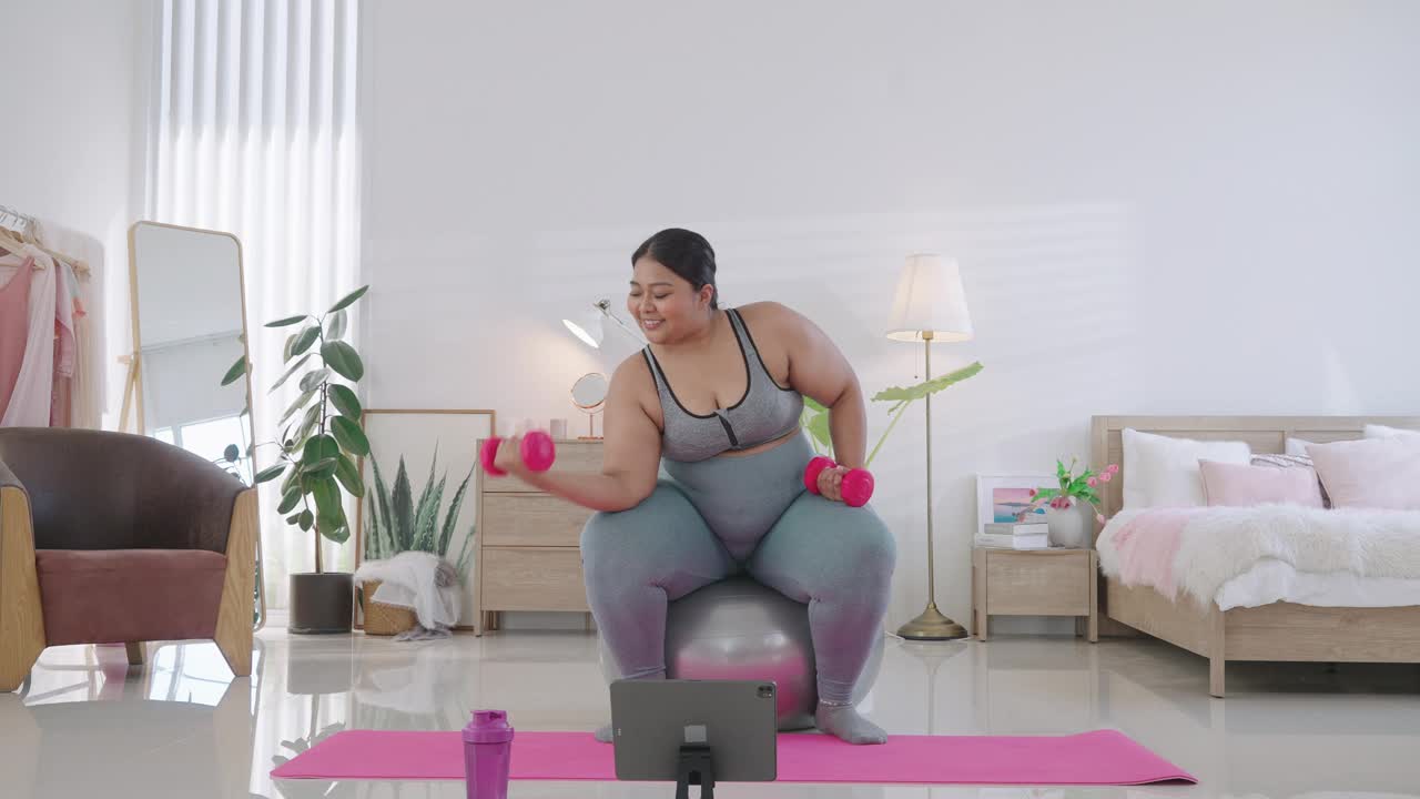 胖女人举哑铃在家锻炼视频素材