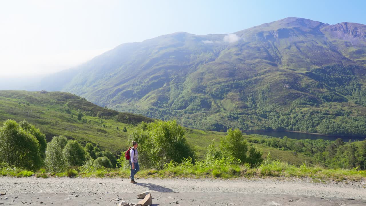 全景的妇女徒步旅行在风景如画的高地景观山脊附近格伦科，苏格兰视频素材