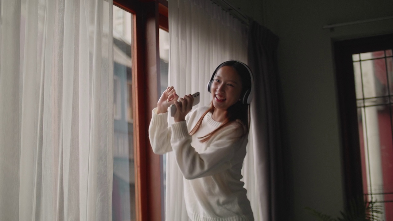 年轻的亚洲女人在家里跳舞视频素材