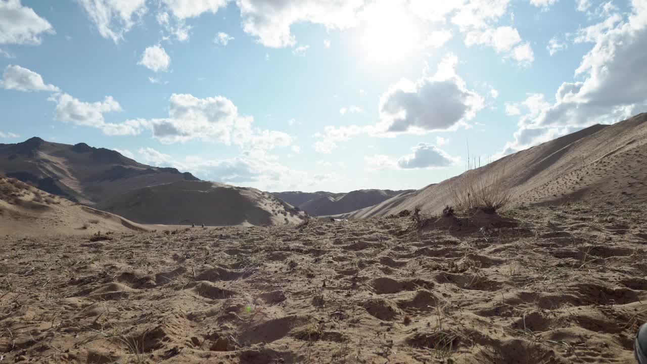 两个旅行者走在风景秀丽的沙地绿洲上视频素材