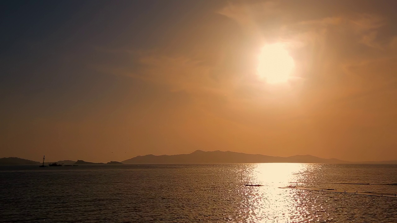 海上的夕阳。背景是山脉。视频下载