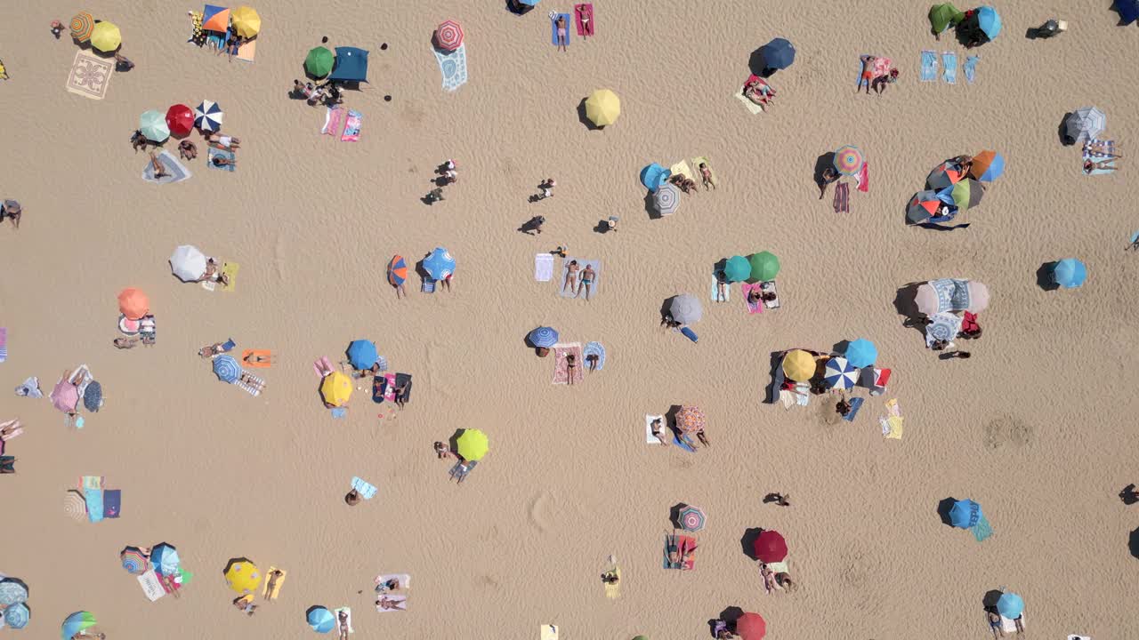 人们在葡萄牙里斯本附近的卡帕里卡海岸海滩上享受夏日美景的鸟瞰图视频素材