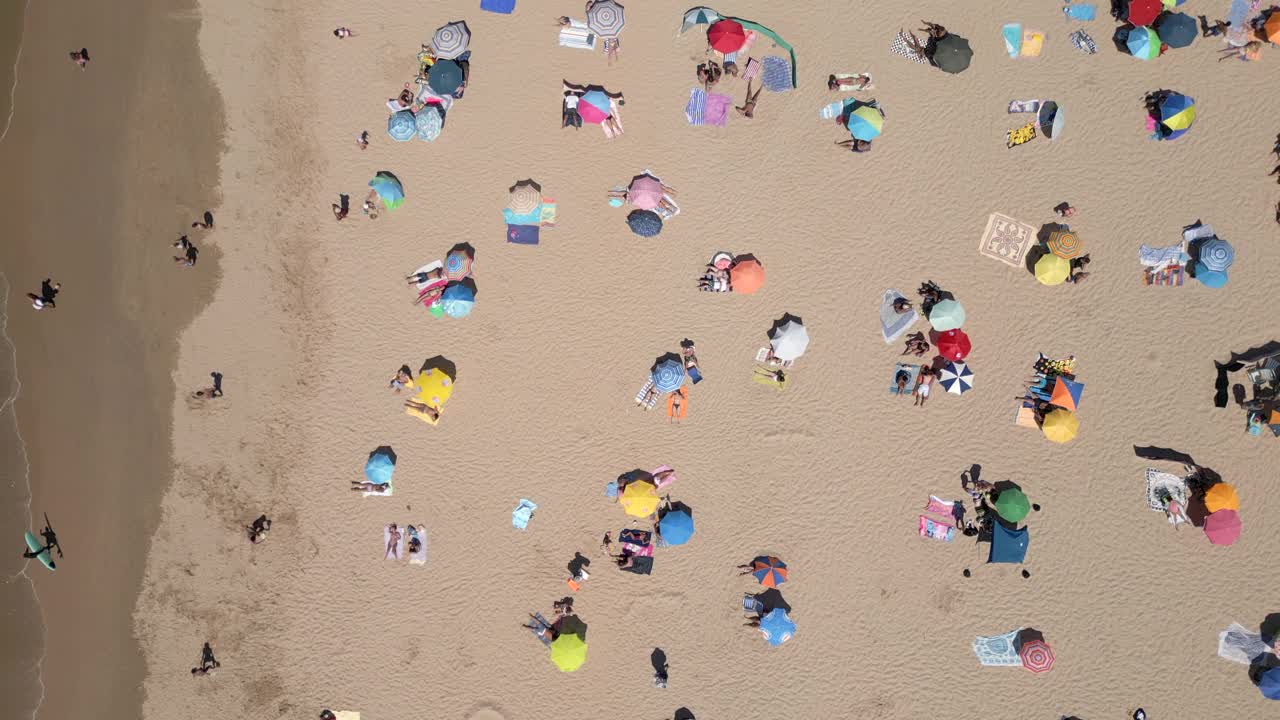 人们在葡萄牙里斯本附近的卡帕里卡海岸海滩上享受夏日美景的鸟瞰图视频素材