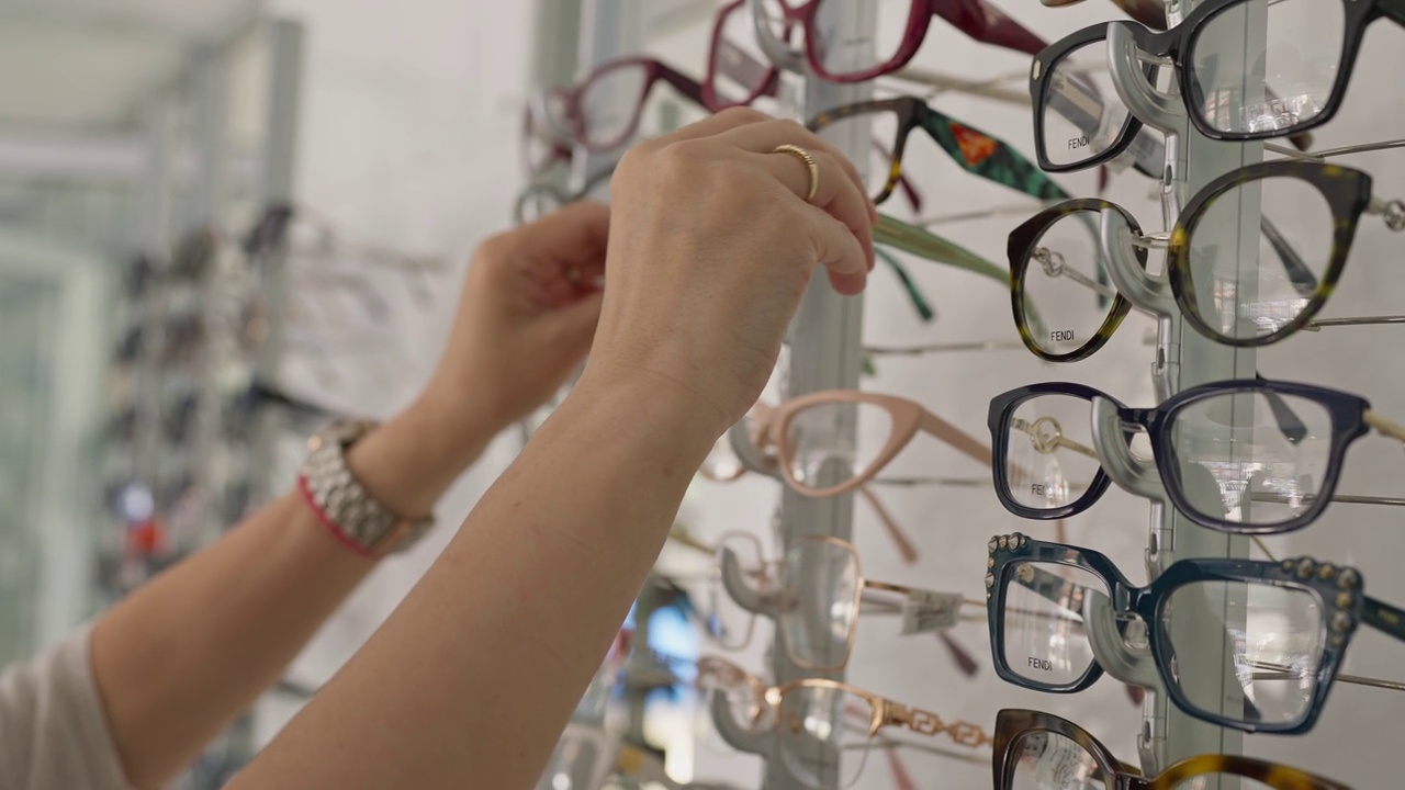 一位女士在眼镜店挑选一副眼镜视频素材