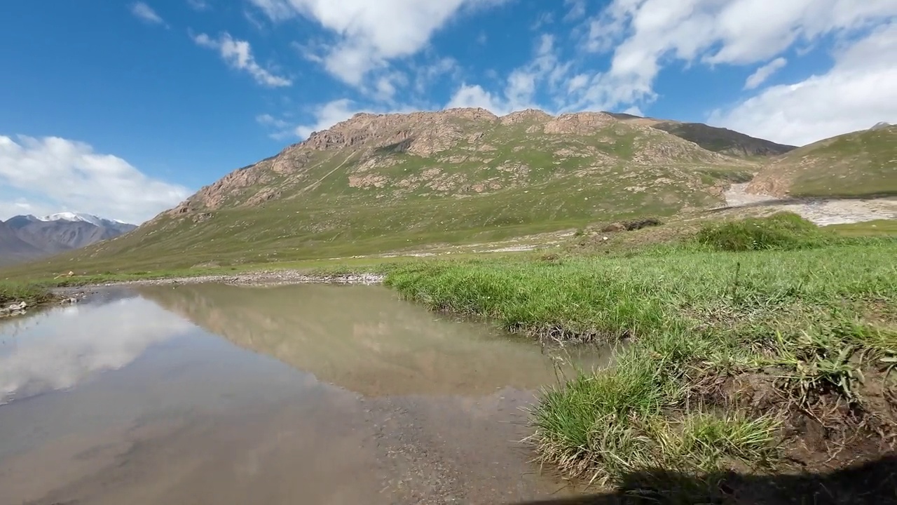 夏天在山间河岸开车时穿过水坑。汽车的观点视频素材