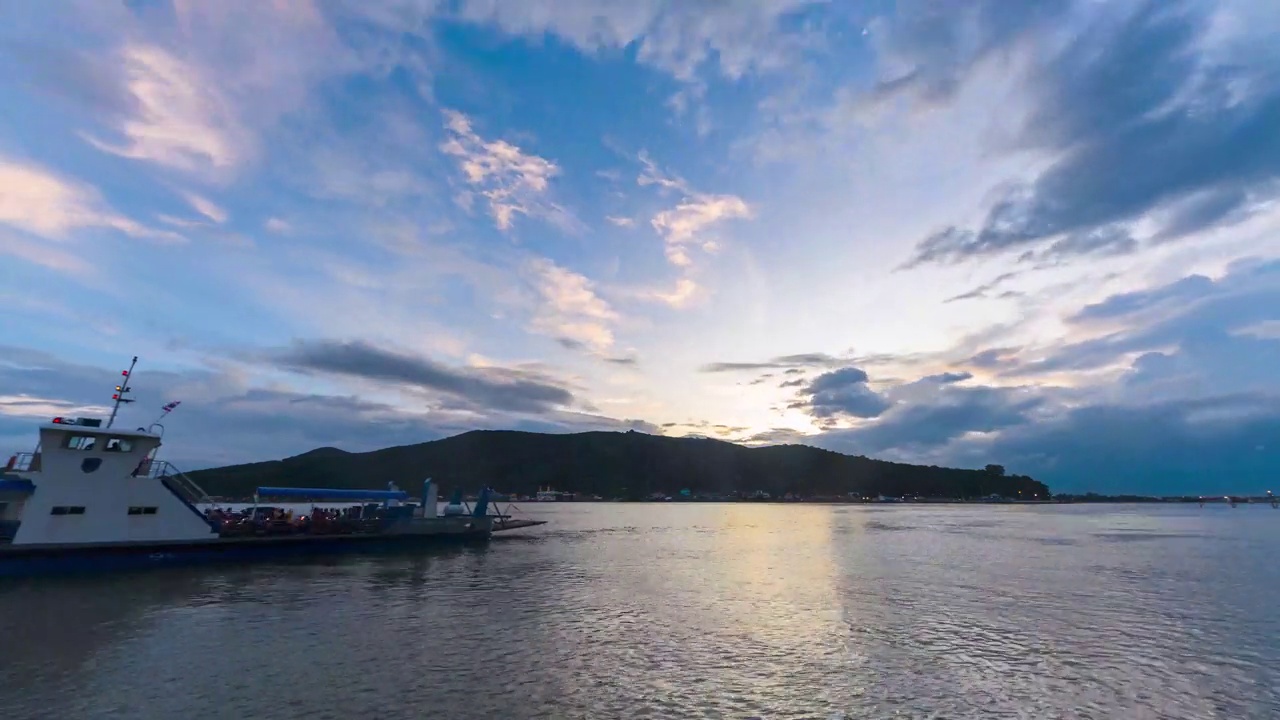 从白天到夜晚，夕阳在湖面上随着帆船和渡船在湖面上航行视频素材