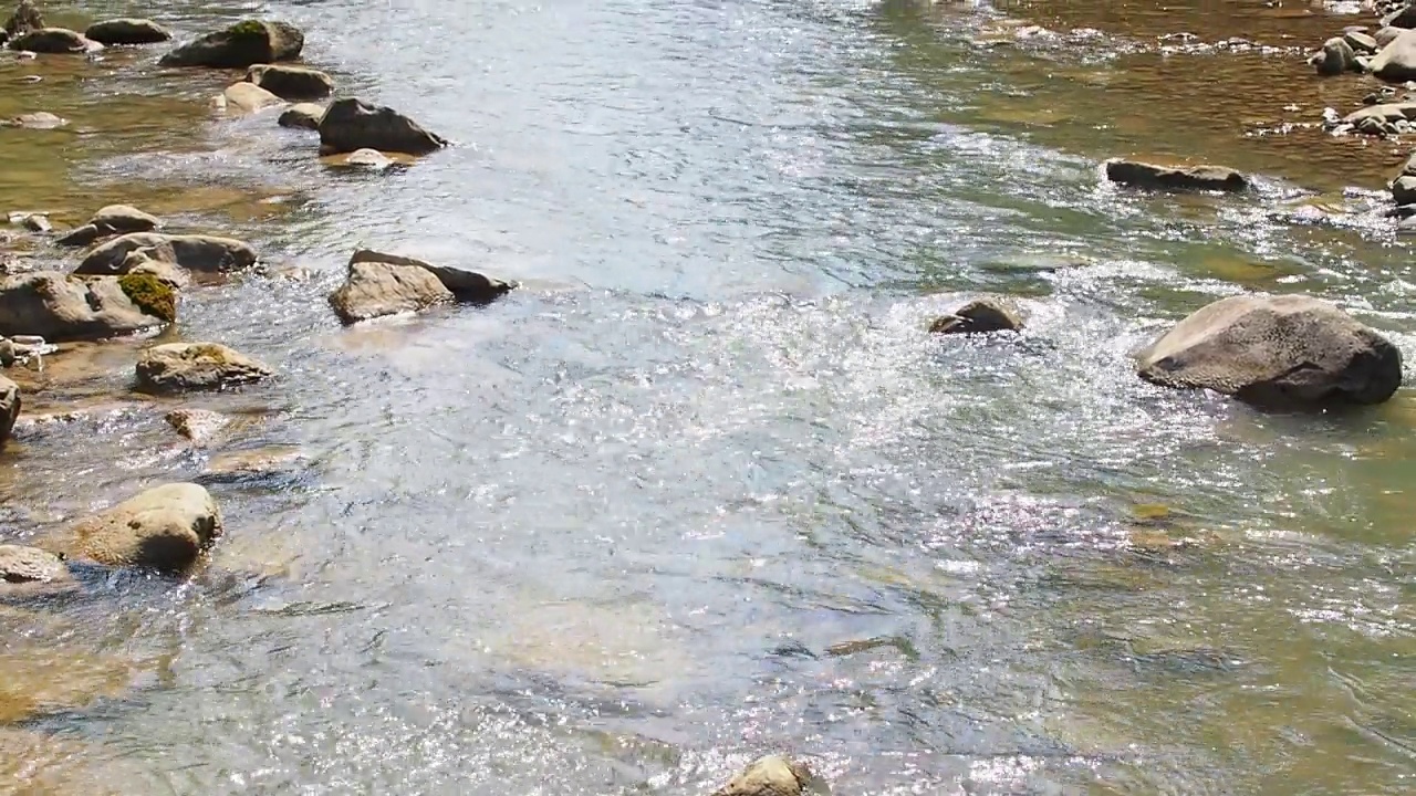 小河湍急而生动地流过它荒凉的石谷视频素材