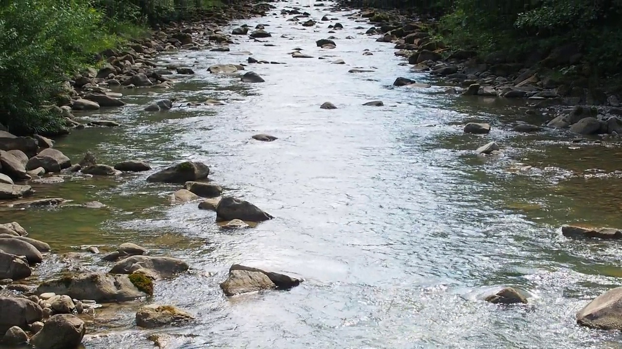 小河湍急而生动地流过它荒凉的石谷视频素材