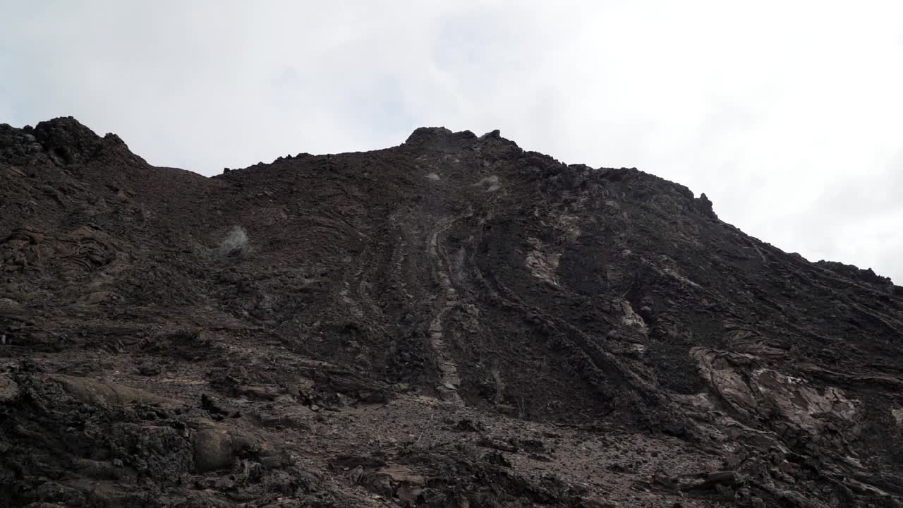 在厄瓜多尔加拉帕戈斯群岛的两个海滩之间，巴托洛梅岛火山景观的陡峭悬崖和著名的尖顶岩视频素材