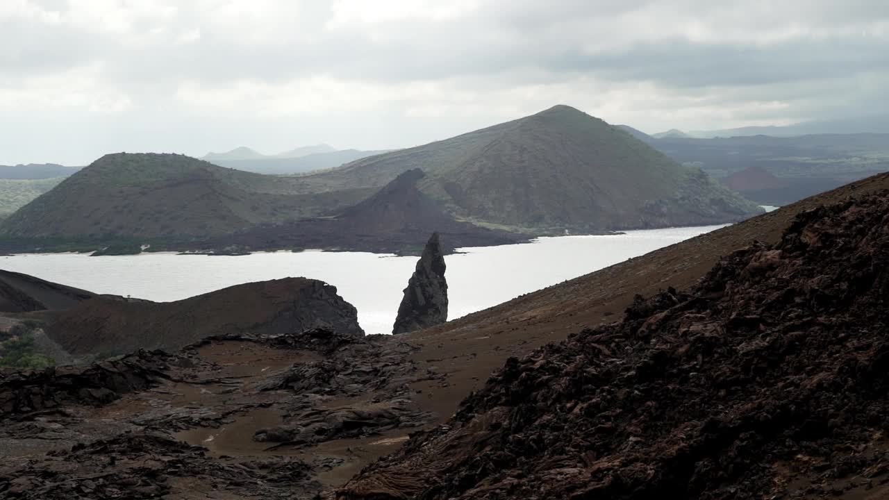 在厄瓜多尔加拉帕戈斯群岛的两个海滩之间，巴托洛梅岛火山景观的陡峭悬崖和著名的尖顶岩视频素材