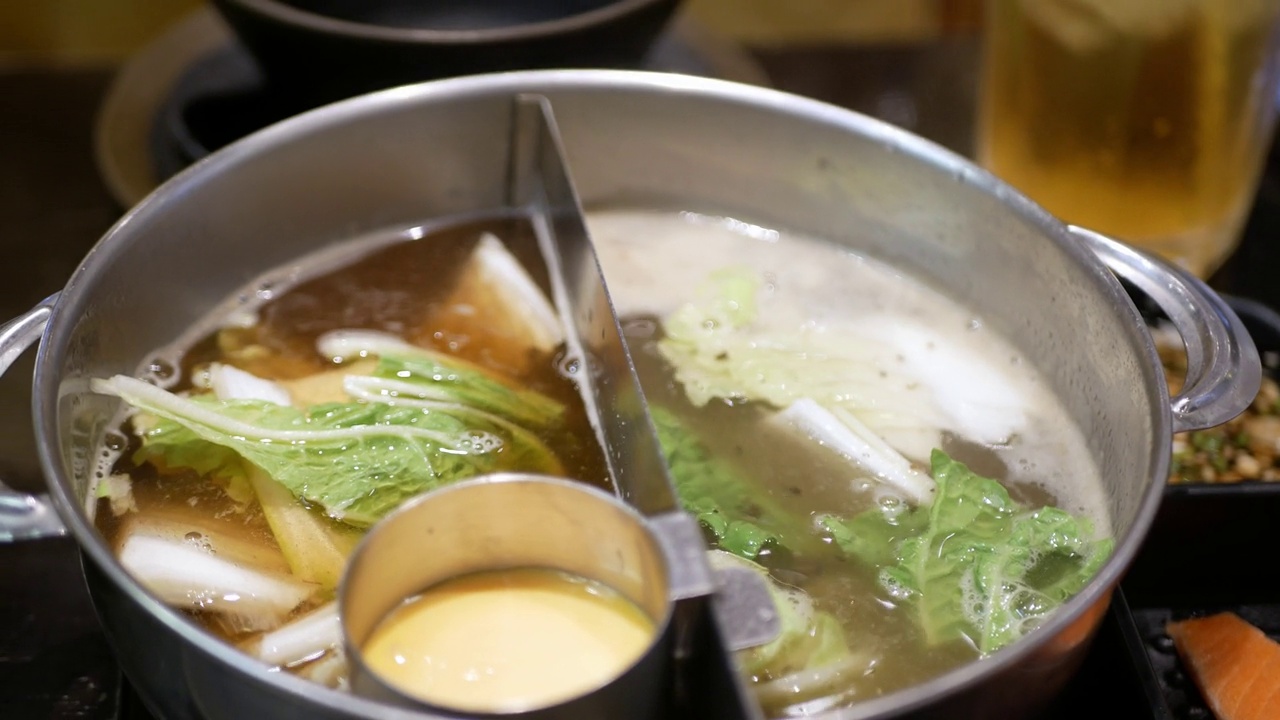 火锅涮锅与各种蔬菜的特写，将肉丸放入滚烫的火锅汤中烹煮。日本亚洲美味健康火锅涮食品视频素材