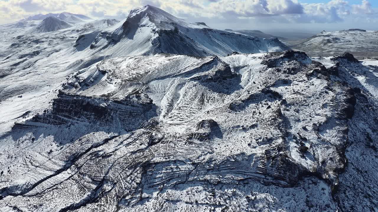 冰雪覆盖的冰岛山脉，鼓舞人心的史诗般的冬季全景，在山峰上空飞行。视频素材