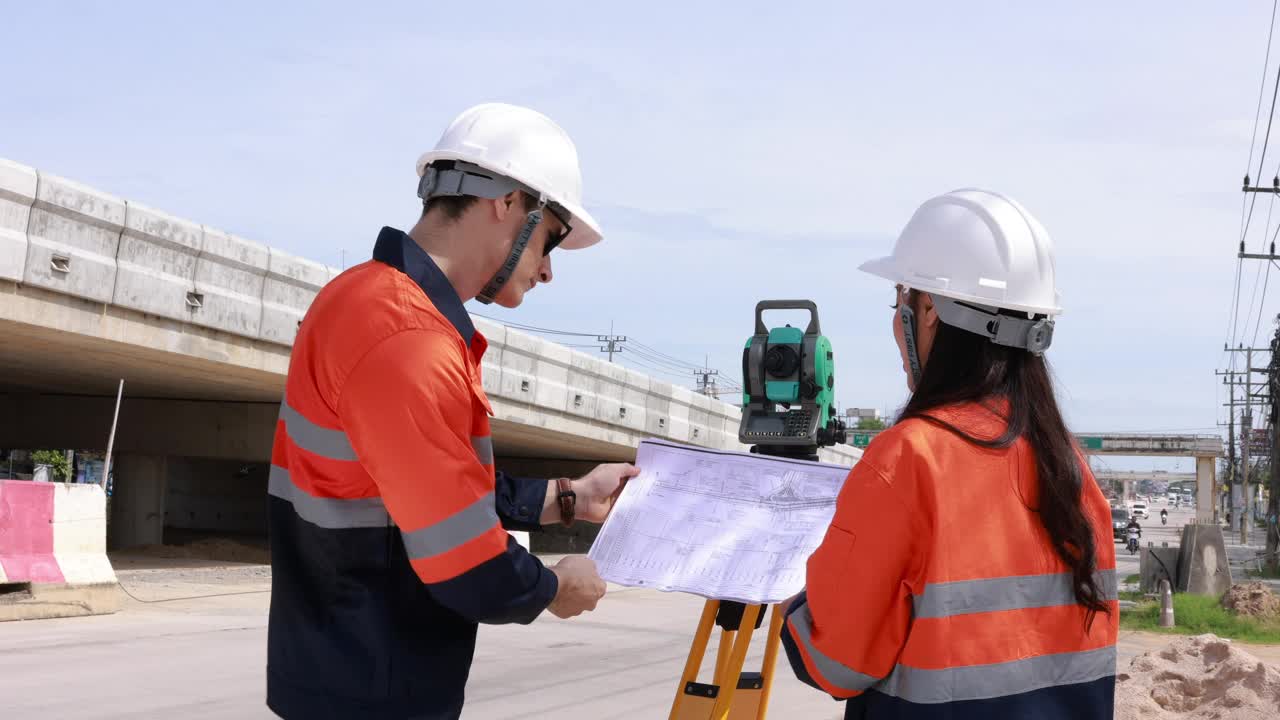 工程师使用经纬仪设备和寻找蓝图的建设项目进行路线测量，在交叉路口建造一座桥梁，以减少高峰时段的交通拥堵。视频素材