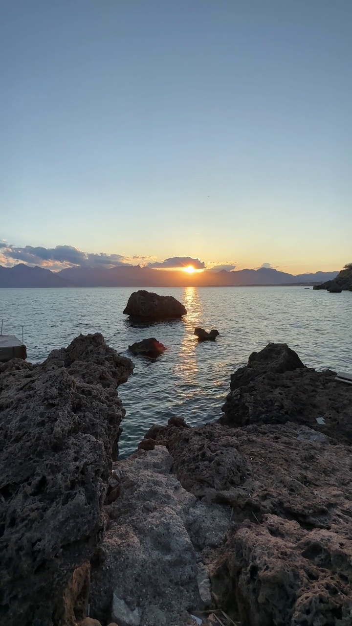 独特的日落海景，穿过岩石。视频素材