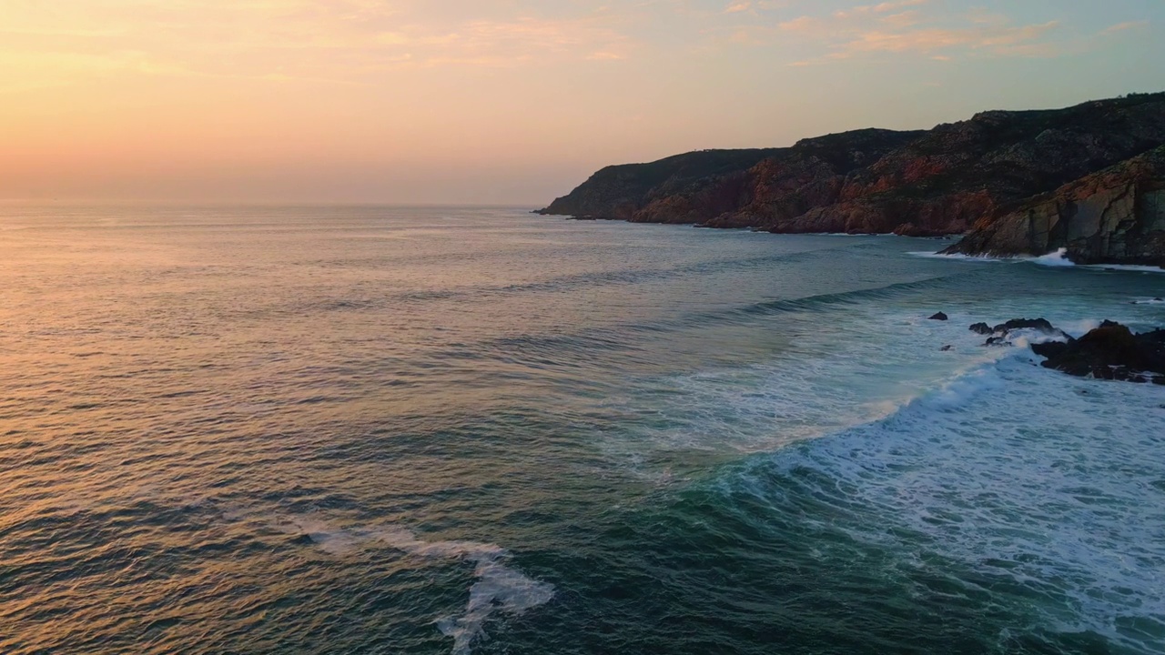 海浪日落沙滩自然。海水溅起粗糙的悬崖黄昏海岸视频素材