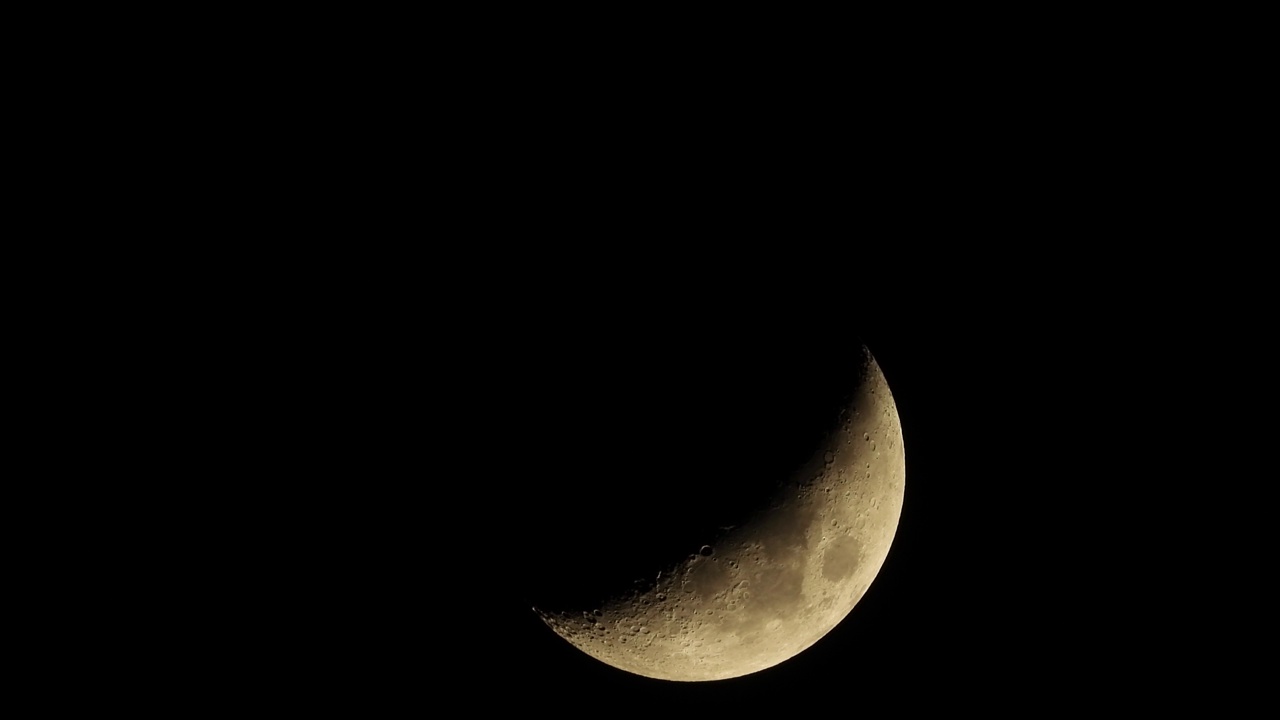 新月穿过黑色的夜空背景。上弦月，视频素材