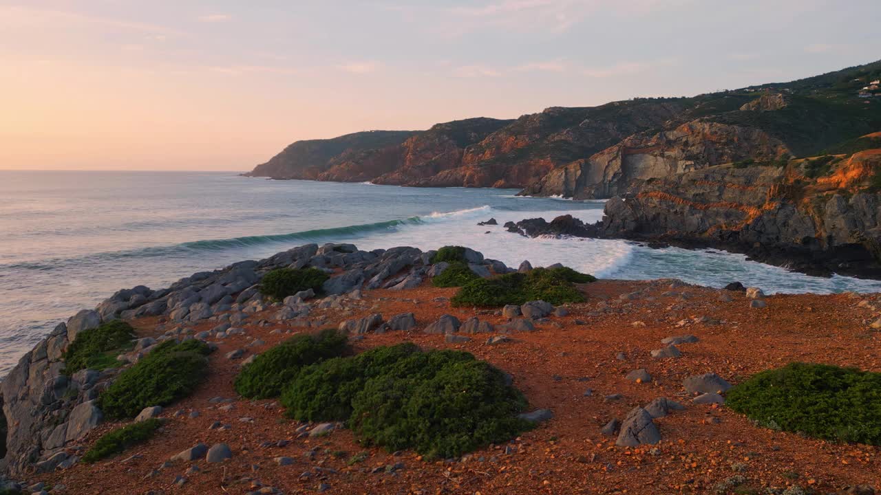 海边沙滩日落自然。海浪溅起火山岩，海岸山丘视频素材