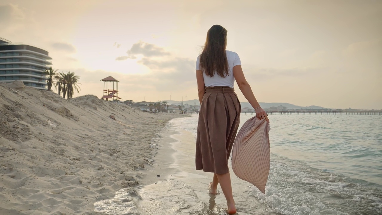 慢动作的女人享受她的假期在沙滩上，走在丝巾。旅行、旅程和旅游的概念视频素材