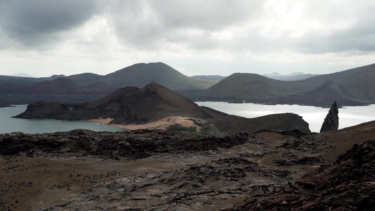 在厄瓜多尔加拉帕戈斯群岛的两个海滩之间，巴托洛梅岛火山景观的陡峭悬崖和著名的尖顶岩视频素材