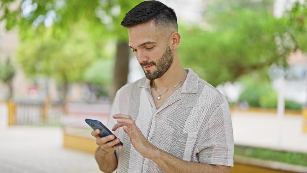 年轻的西班牙裔男子在公园里一边用智能手机跳舞一边听音乐视频素材