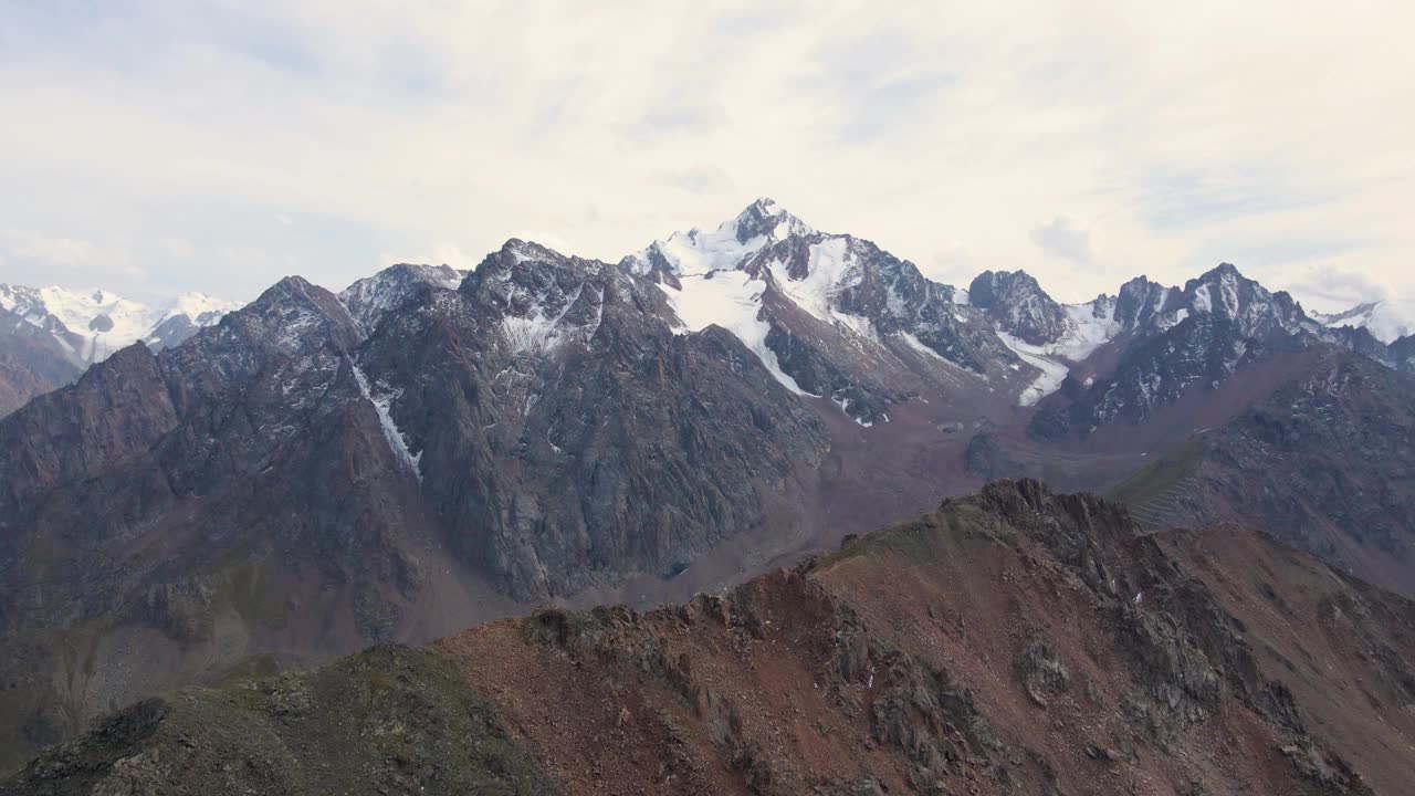 飞过山脊，背后是白雪覆盖的山峰视频下载