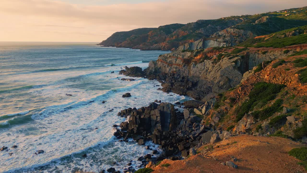 空中飞行的岩石海岸海浪打破海岸线。海水溅在悬崖上视频素材