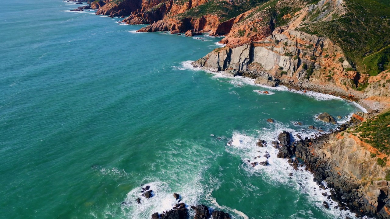 电影全景，岩石海岸被平静的海水冲刷。空中涌浪视频素材