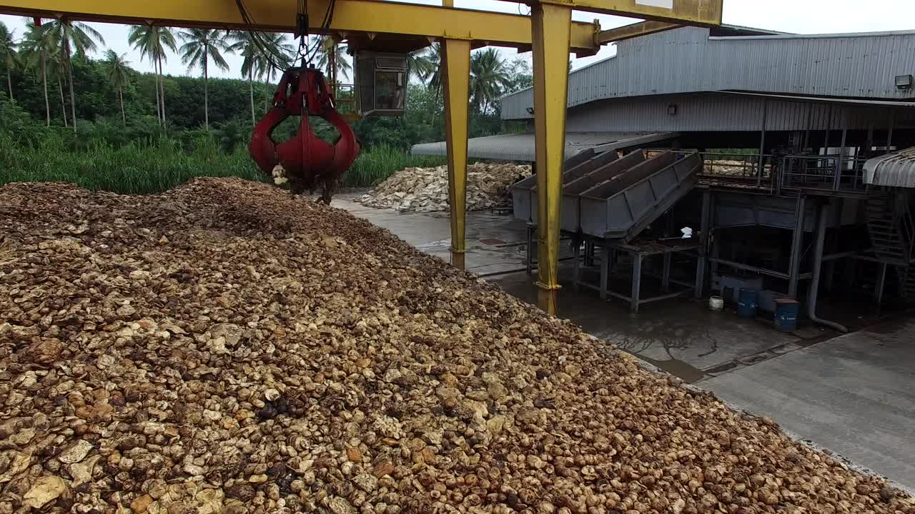 干燥后的天然生胶，用机械抓斗工业机在工厂室外区堆放在水泥地面上。视频素材