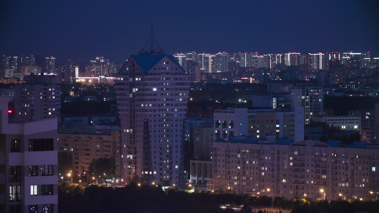 现代多层住宅上空的深蓝色夜空。高架景观城市天际线。夜间灯光照明延时。背景夜间延时。城市夜景视频素材