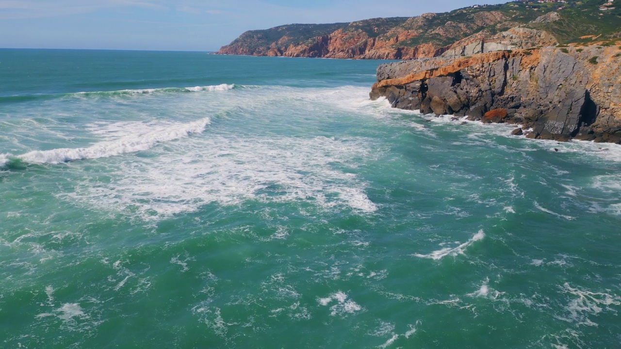 蓝色的海浪拍打着石头海岸线。空中海水冲刷悬崖。视频素材