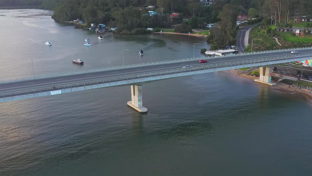 现代化的多车道桥横跨河流，汽车在上面行驶。交通及旅游主题视频素材