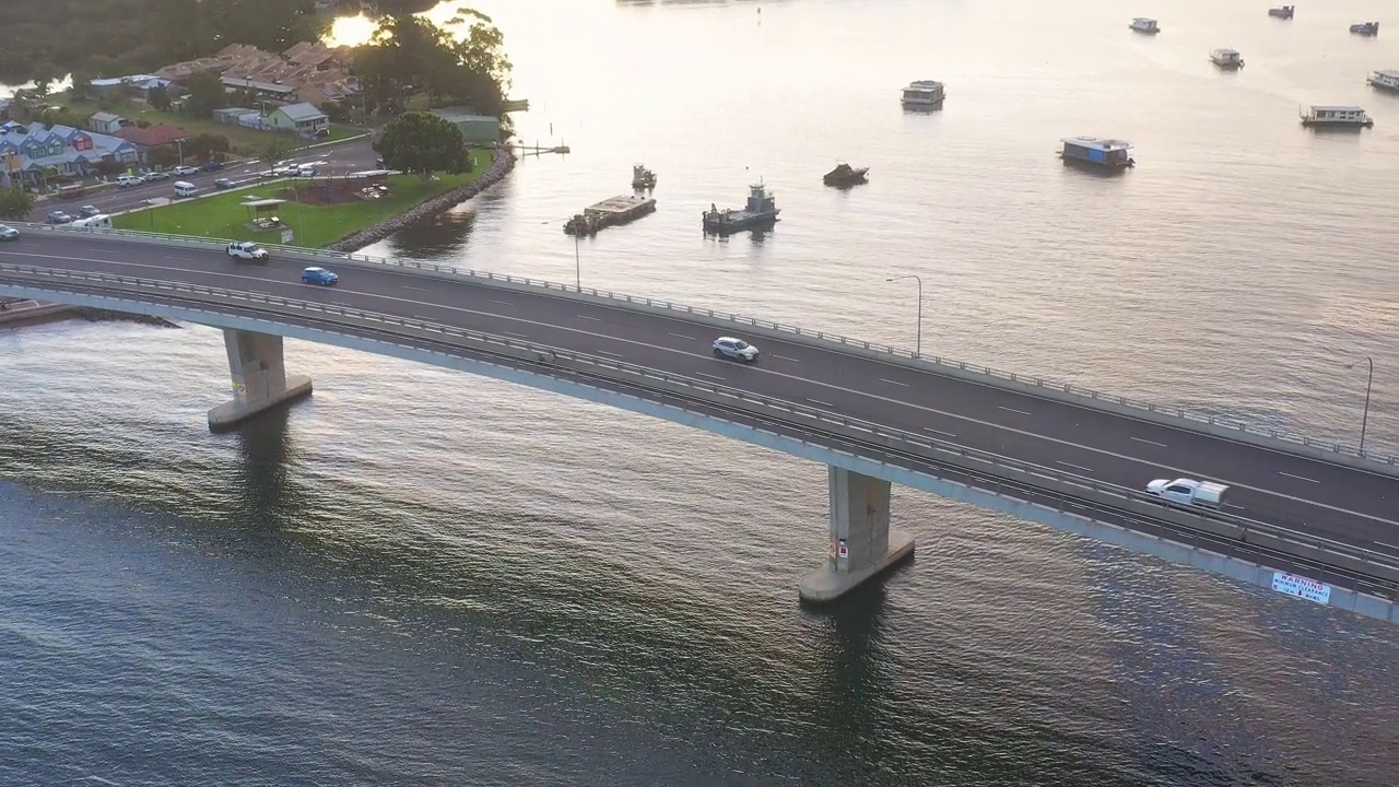 现代化的多车道桥横跨河流，汽车在上面行驶。交通及旅游主题视频素材