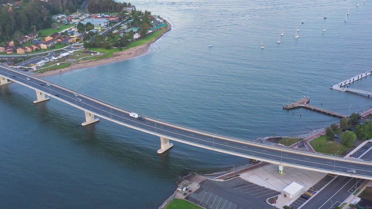 现代化的多车道桥横跨河流，汽车在上面行驶。交通及旅游主题视频素材