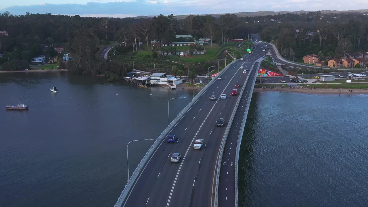 现代化的多车道桥横跨河流，汽车在上面行驶。交通及旅游主题视频素材