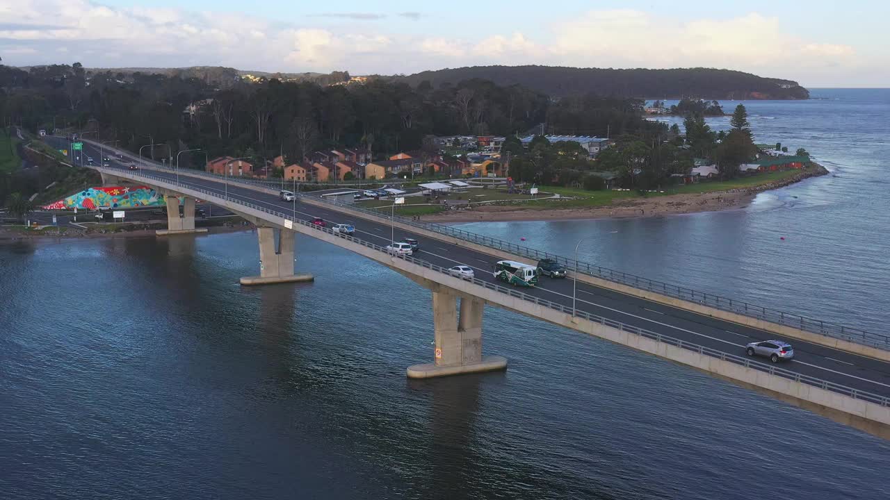 现代化的多车道桥横跨河流，汽车在上面行驶。交通及旅游主题视频素材