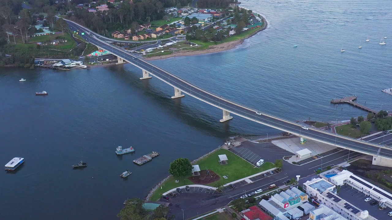 现代化的多车道桥横跨河流，汽车在上面行驶。交通及旅游主题视频素材