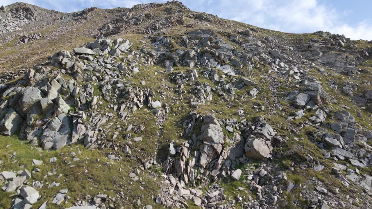 在山腰上飞行，可以看到巨石和山谷景观视频素材