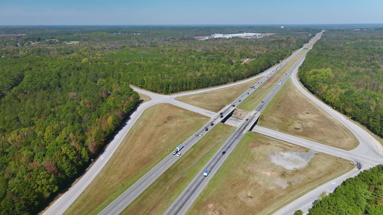 高速公路出口交叉路口的高架视图，车道上有快速移动的车辆和卡车。美国州际交通基础设施视频素材