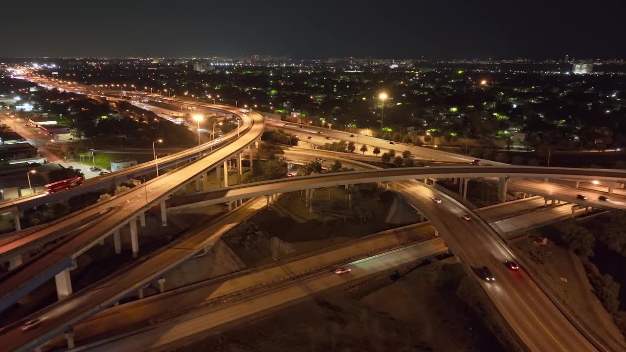 鸟瞰美国高速公路交汇处的夜间与快速行驶的车辆在迈阿密，佛罗里达州。从上面看美国的交通基础设施视频素材