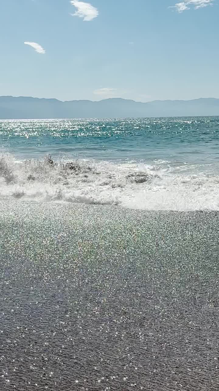 海浪来了又去，背景是群山视频素材