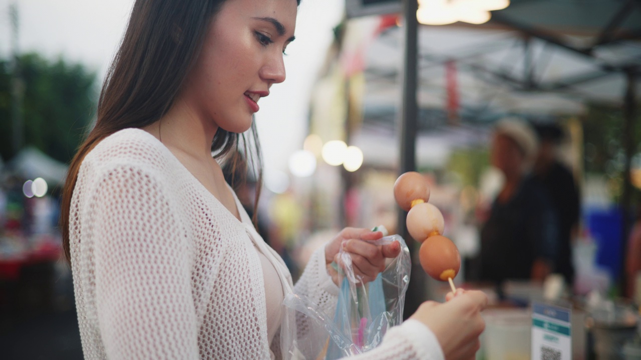 年轻的亚洲女游客在泰国的街头食品市场购物视频素材