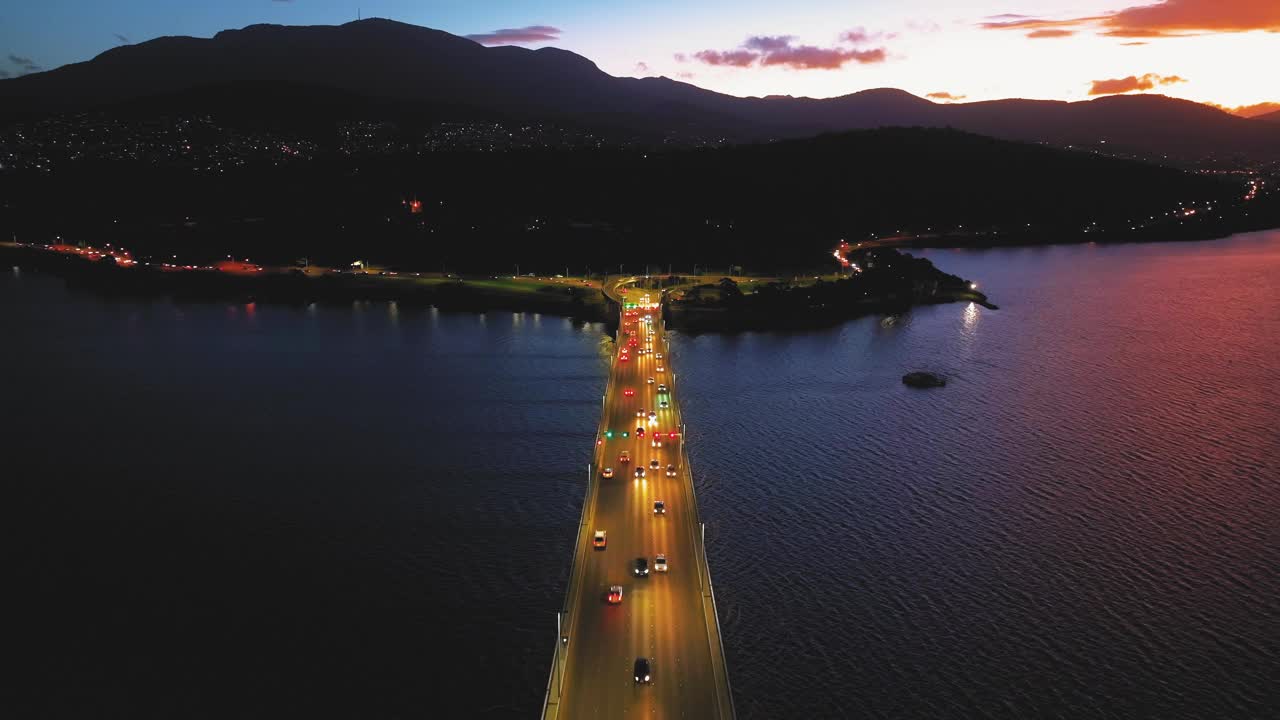 鸟瞰夜间横跨岛屿的桥梁交通视频素材