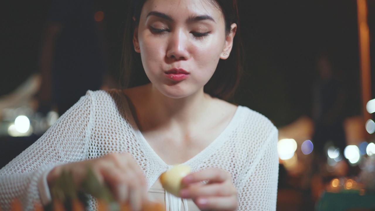 年轻的亚洲女游客一边享用煮鸡蛋一边录制视频视频下载