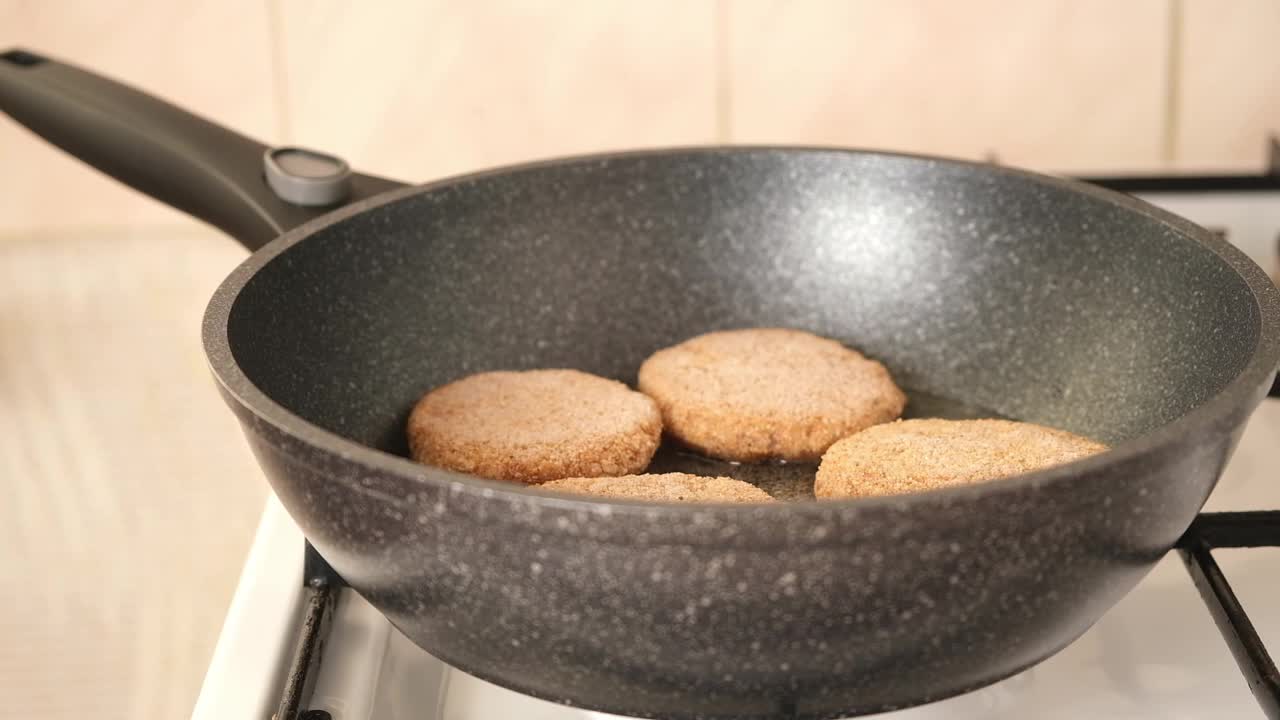 一位妇女在煎锅上盖上自己做的冷冻肉饼。自制的准备。视频素材